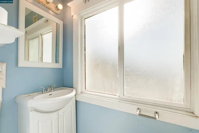 a bathroom with a sink a mirror and a window