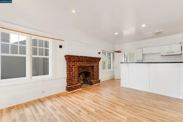 a view of empty room with wooden floor and fireplace
