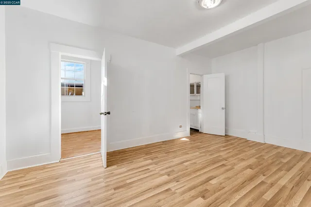 a view of an empty room with wooden floor