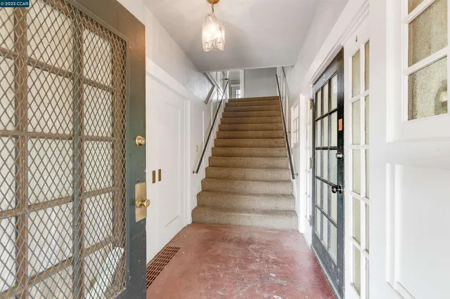 a view of staircase with lots of frames on wall and a large window