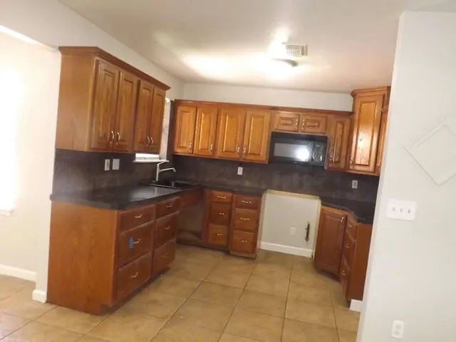 a kitchen with a sink a stove and cabinets