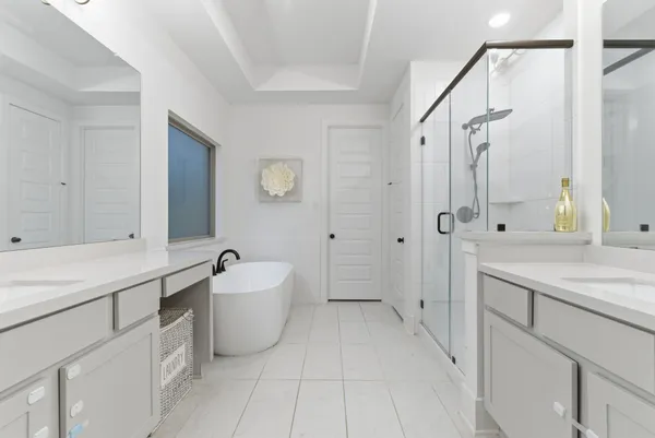 a spacious bathroom with a sink double vanity mirror and a bathtub