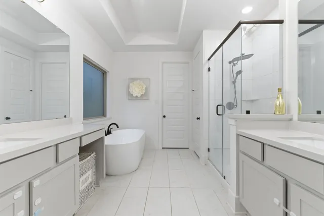 a spacious bathroom with a sink double vanity mirror and a bathtub