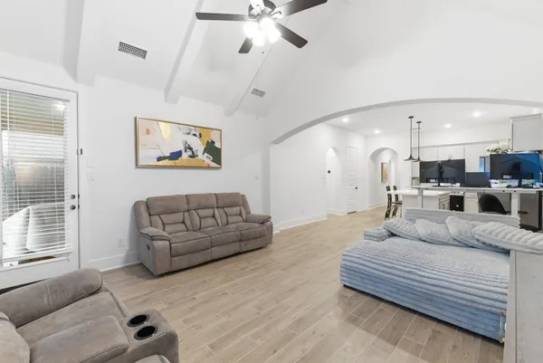 a living room with furniture kitchen view and a window