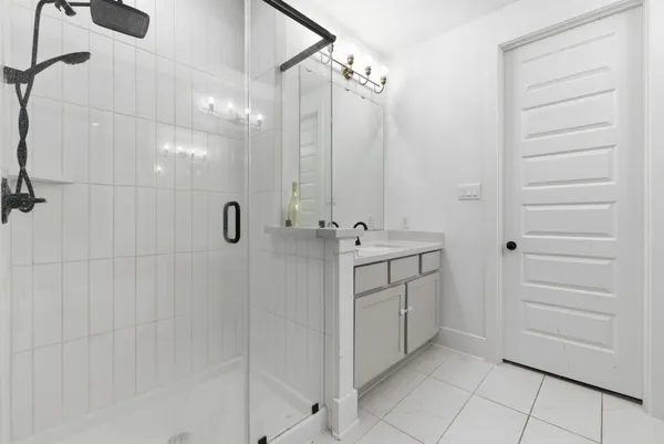 a bathroom with a double vanity sink a mirror and shower