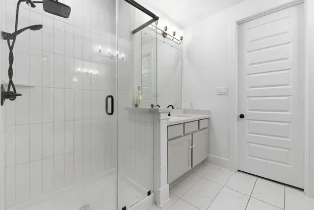 a bathroom with a double vanity sink a mirror and shower