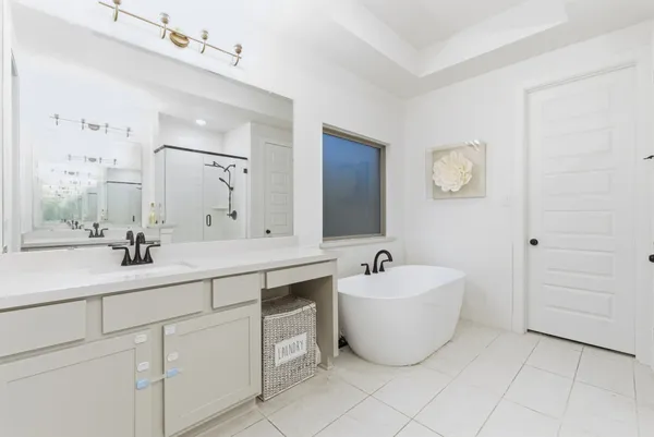 a spacious bathroom with a double vanity sink mirror and bathtub