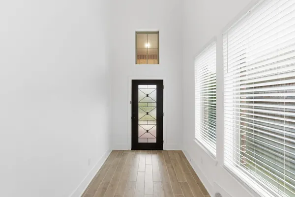 a view of an empty room with window and wooden floor