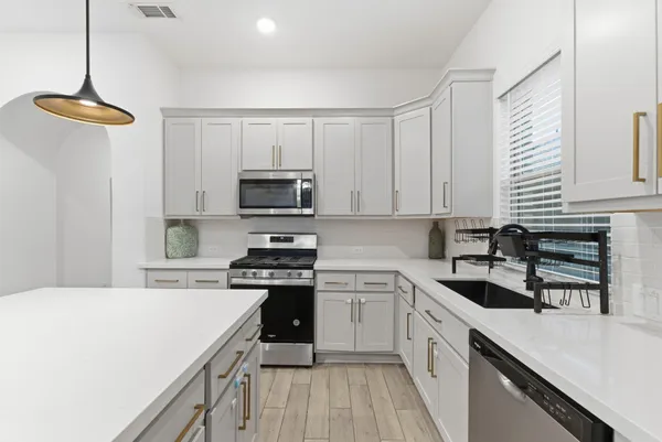 a kitchen with a sink a stove and cabinets