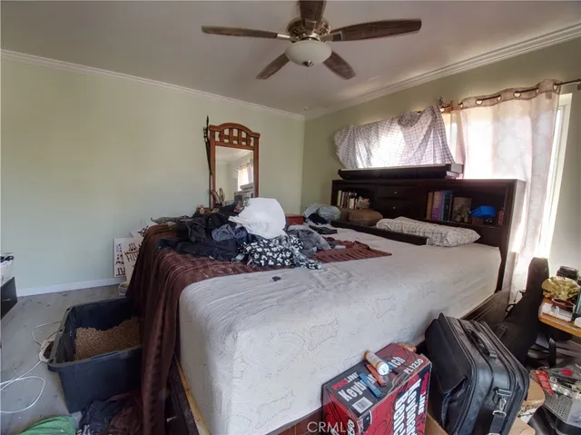 a bedroom with a bed and a lamp on a dresser