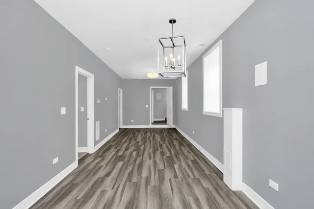 a view of a room with wooden floor staircase and a kitchen space