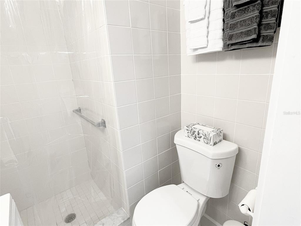 16102 1st Street East Redington Beach, FL 33708 - Photo 23 of 39 a white toilet sitting next to a bathroom sink