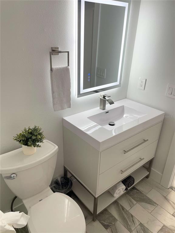 16102 1st Street East Redington Beach, FL 33708 - Photo 24 of 39 a white toilet sitting next to a bathroom sink