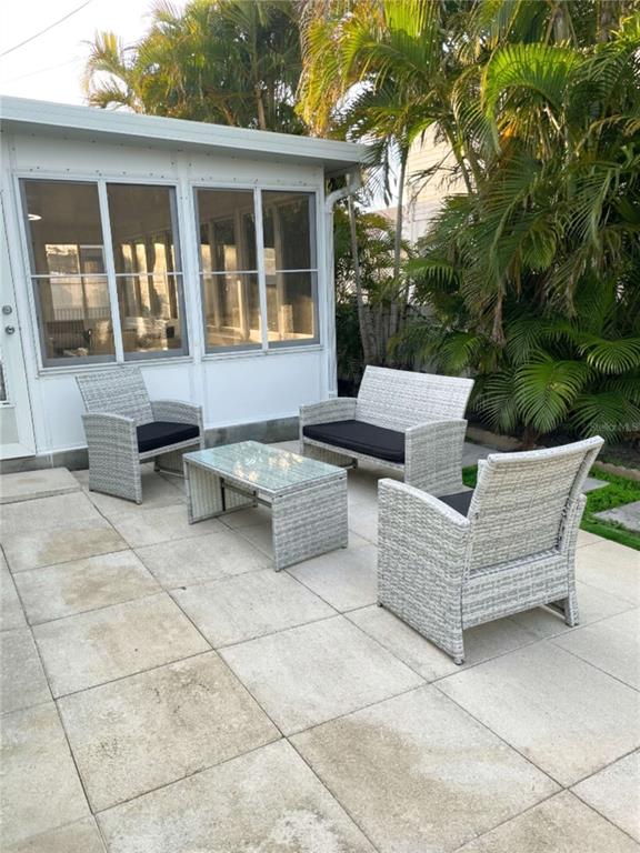 16102 1st Street East Redington Beach, FL 33708 - Photo 38 of 39 a view of a patio with couches and a fire pit and an umbrella