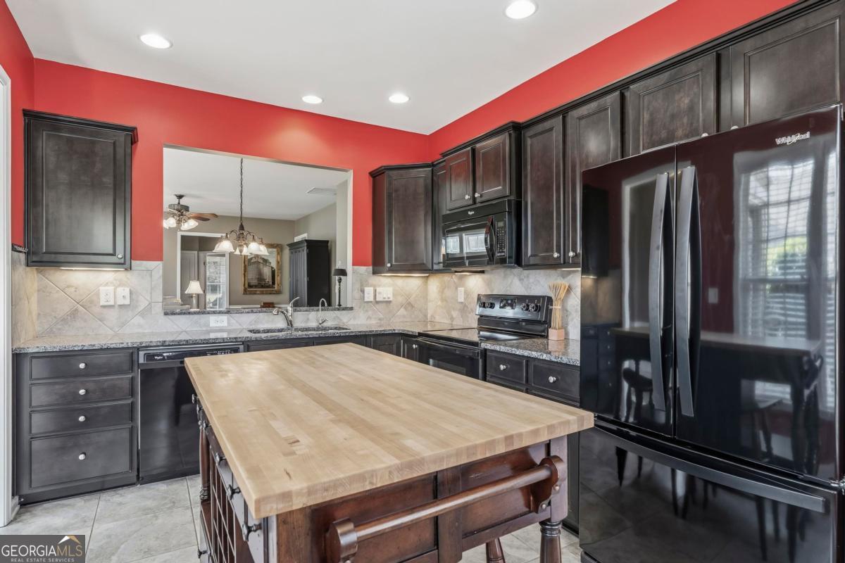 1320 Summer Hollow Road Greensboro, GA 30642 - Photo 11 of 45 a kitchen with a table chairs refrigerator and microwave