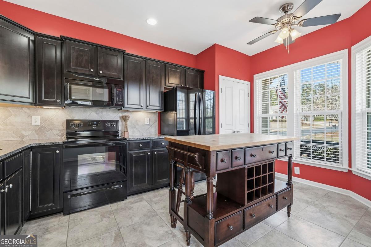 1320 Summer Hollow Road Greensboro, GA 30642 - Photo 13 of 45 a kitchen with stainless steel appliances granite countertop a stove a sink and a microwave