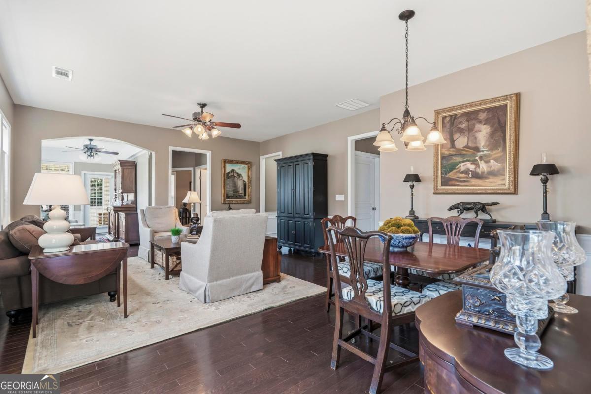 1320 Summer Hollow Road Greensboro, GA 30642 - Photo 21 of 45 a view of a dining room with furniture a chandelier and wooden floor