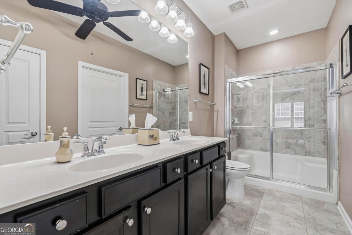 1320 Summer Hollow Road Greensboro, GA 30642 - Photo 33 of 45 a bathroom with a sink a large mirror and shower