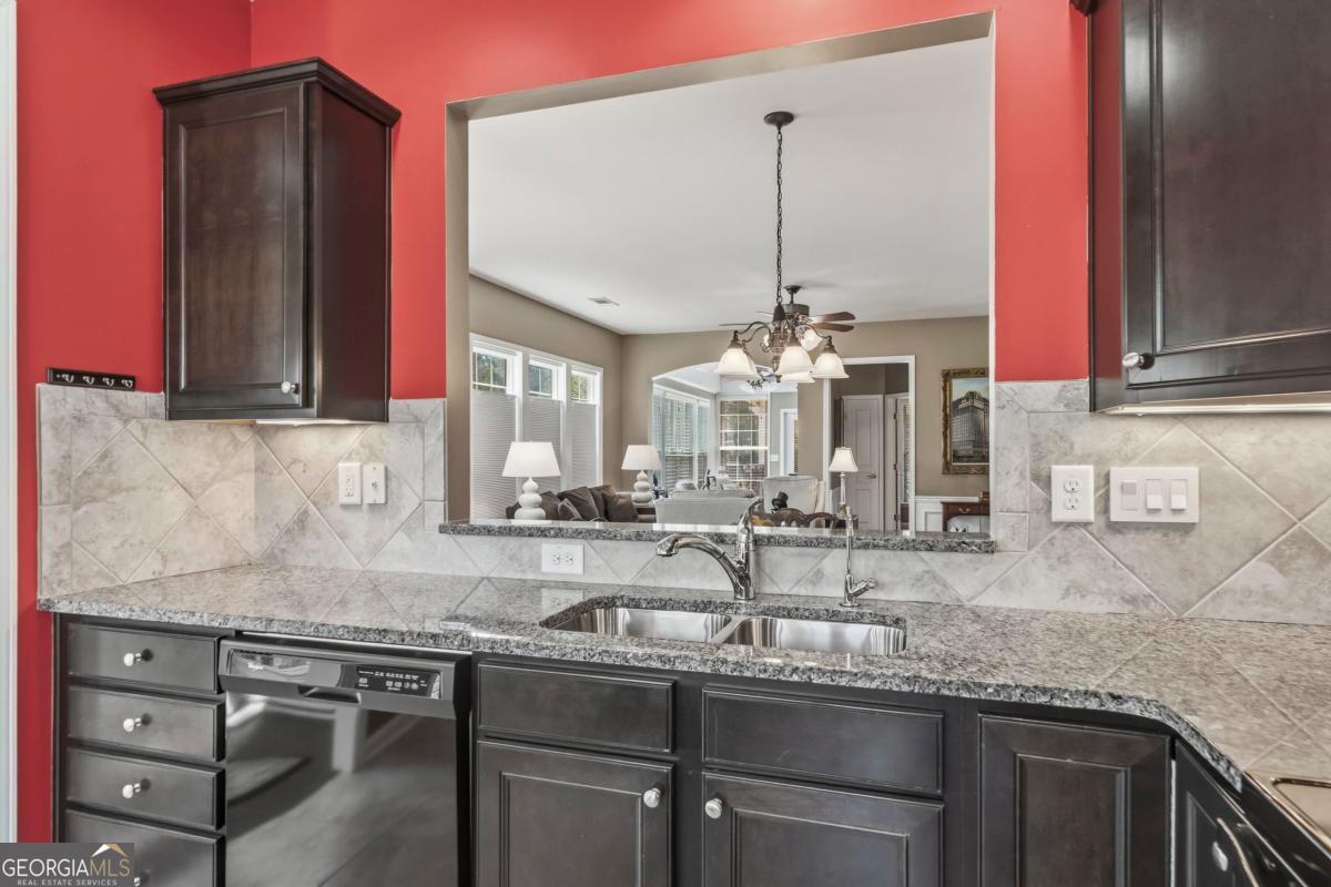 1320 Summer Hollow Road Greensboro, GA 30642 - Photo 9 of 45 a kitchen with stainless steel appliances granite countertop a sink a stove and a wooden cabinets
