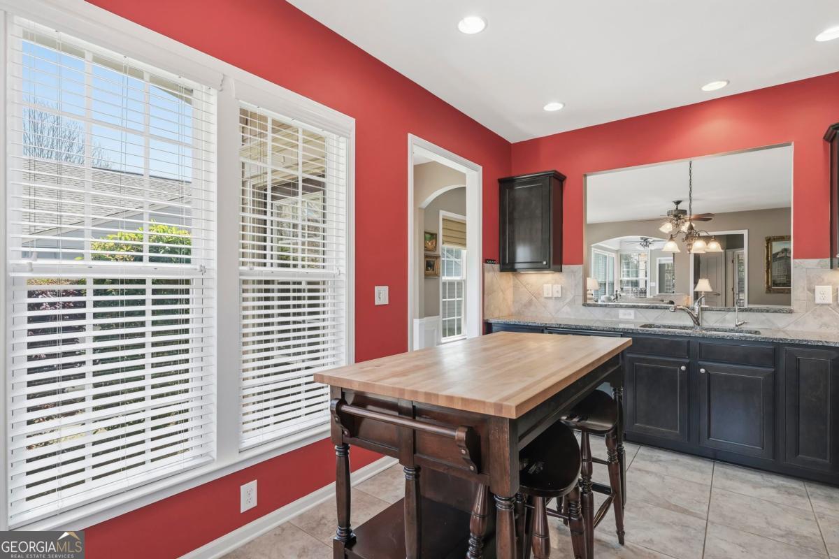 1320 Summer Hollow Road Greensboro, GA 30642 - Photo 10 of 45 a kitchen with a table chairs sink and wooden cabinets