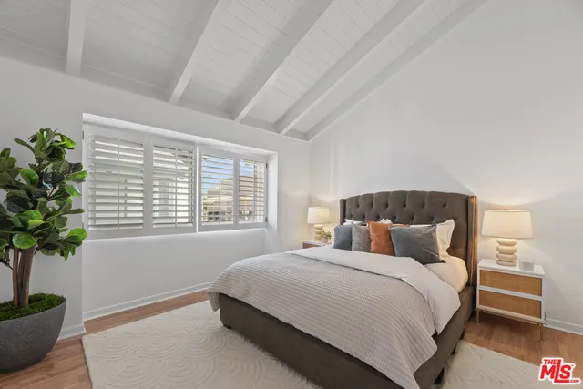 a bedroom with a large bed and a potted plant