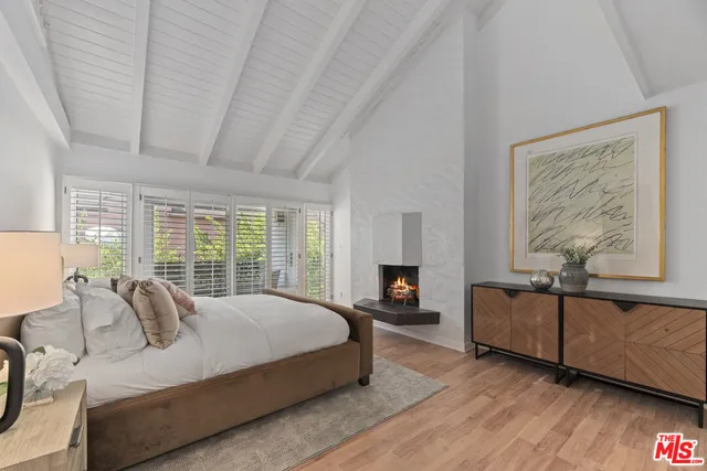 a spacious bedroom with a bed and wooden floor