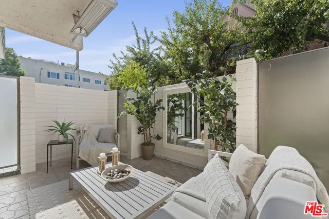 a view of a patio with couches table and chairs and potted plants