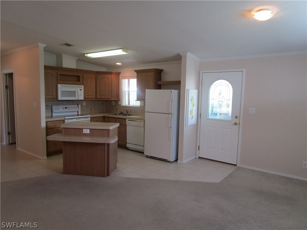 7711 Carpenter Road Bokeelia, FL 33922 - Photo 8 of 18 a kitchen with refrigerator cabinets and stove