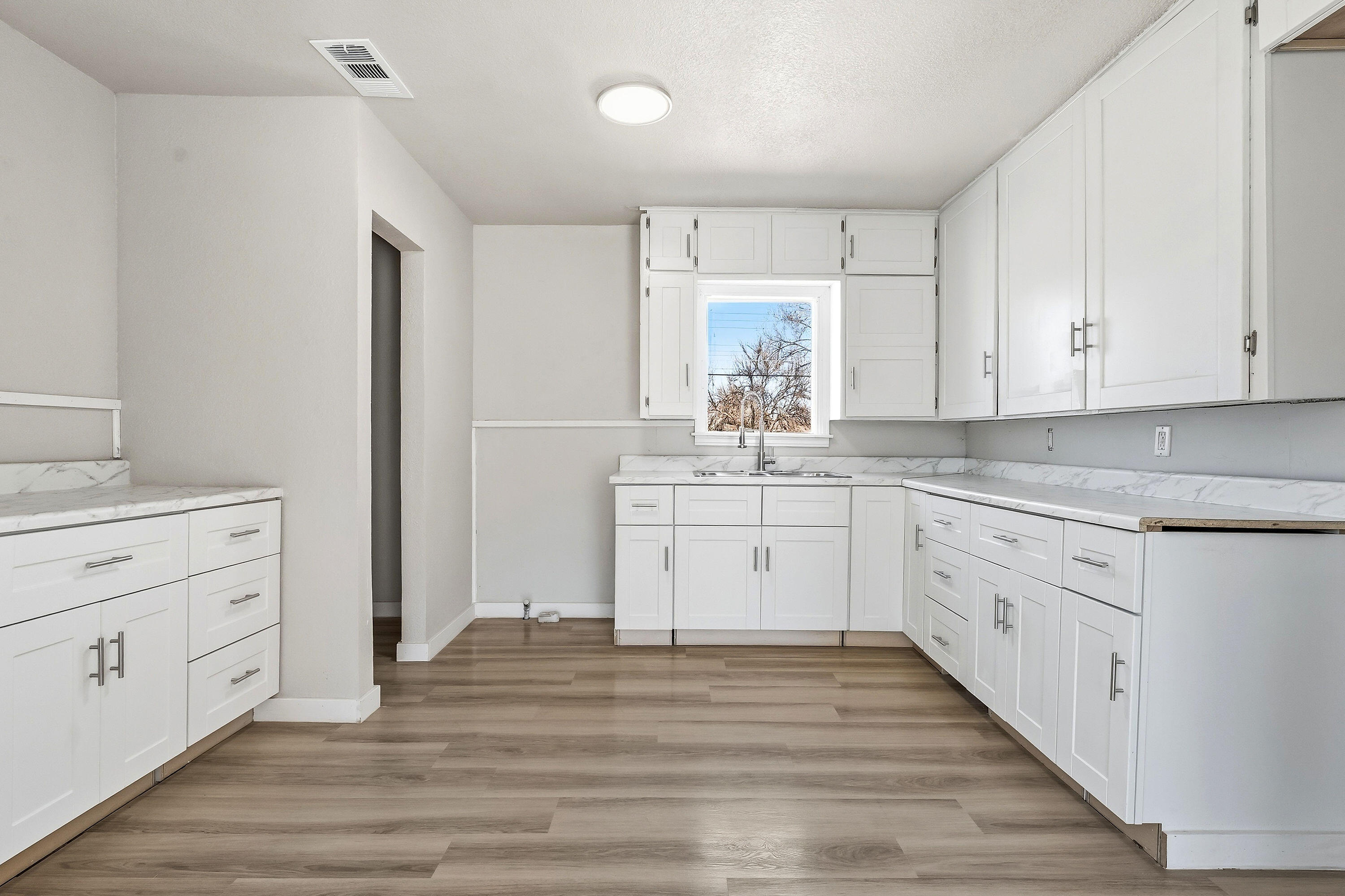 2814 40th Street Lubbock, TX 79413 - Photo 5 of 11 a kitchen with white cabinets stainless steel appliances and sink