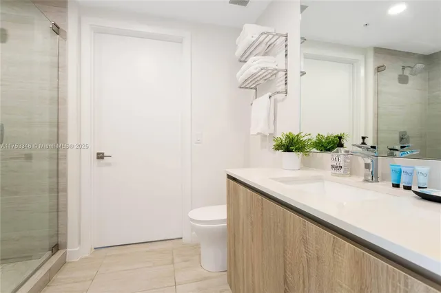 a bathroom with a granite countertop sink a toilet and a mirror