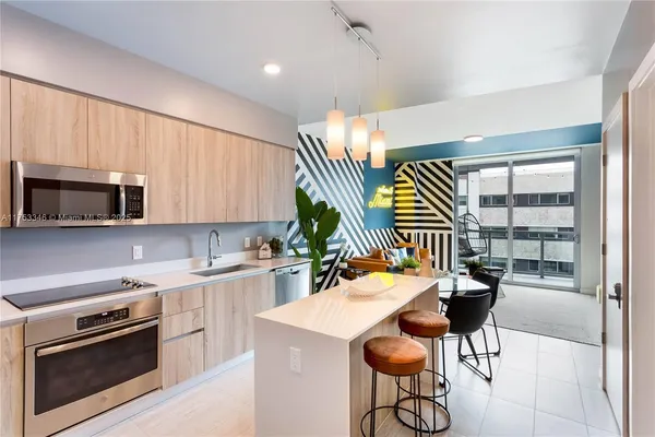 a kitchen with stainless steel appliances kitchen island granite countertop a sink and a stove