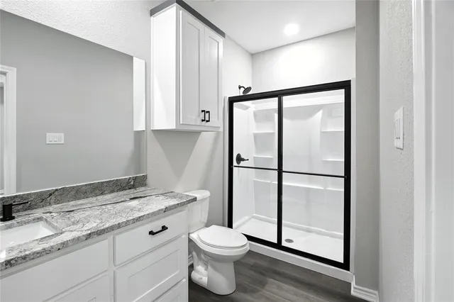 a bathroom with a granite countertop sink toilet and shower