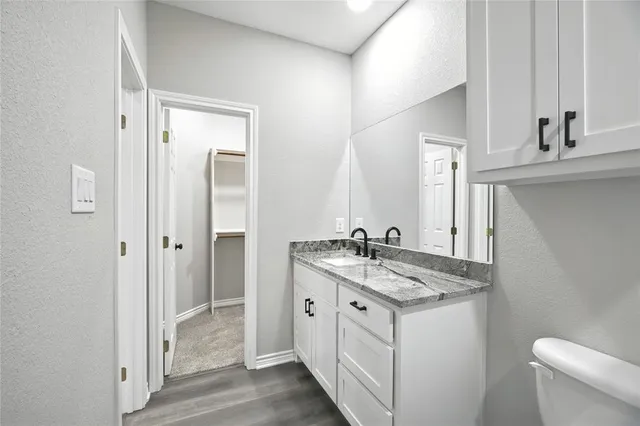 a bathroom with a granite countertop sink and a mirror