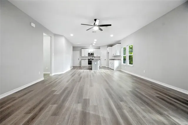 a view of kitchen with cabinets wooden floor and window
