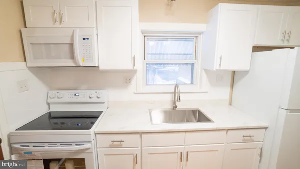a kitchen with a sink cabinets and a window