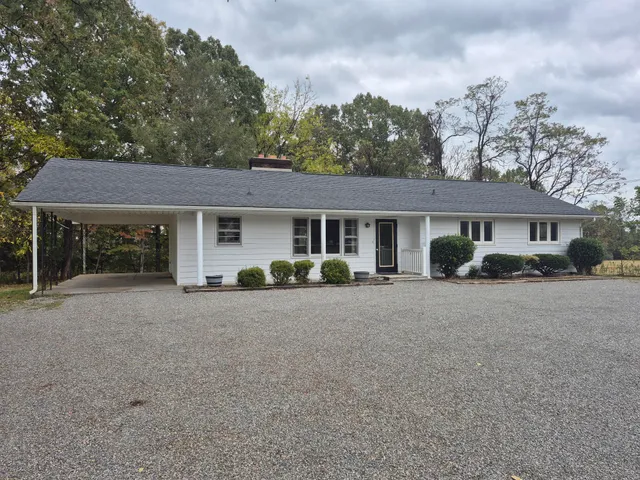 a view of a house with a patio and a yard