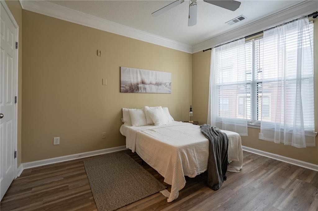400 17th Street Northwest, Unit 1453 Atlanta, GA 30363 - Photo 15 of 27 a bedroom with a bed and wooden floor