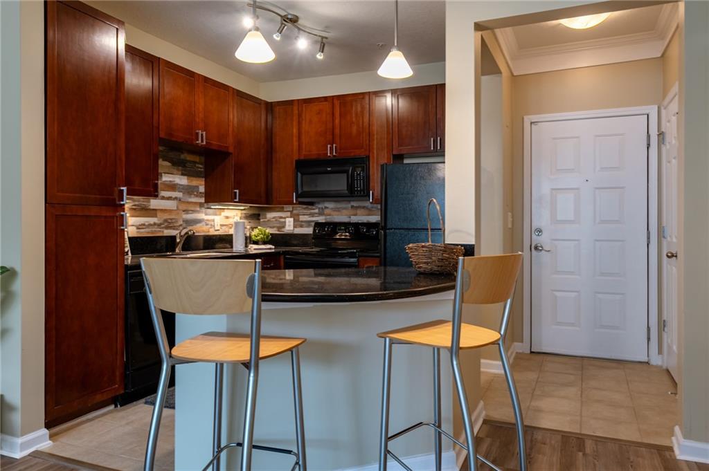 400 17th Street Northwest, Unit 1453 Atlanta, GA 30363 - Photo 4 of 27 a kitchen with stainless steel appliances granite countertop a stove top oven a sink dishwasher a dining table and chairs with wooden floor