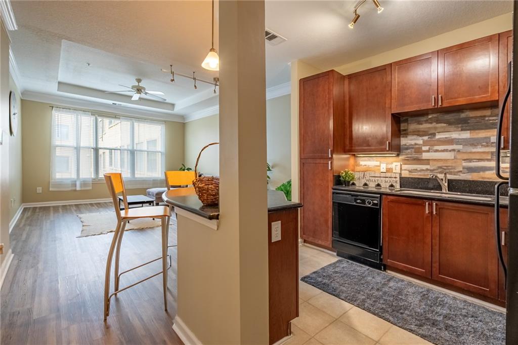 400 17th Street Northwest, Unit 1453 Atlanta, GA 30363 - Photo 5 of 27 a kitchen with stainless steel appliances kitchen island granite countertop wooden floors and wooden cabinets