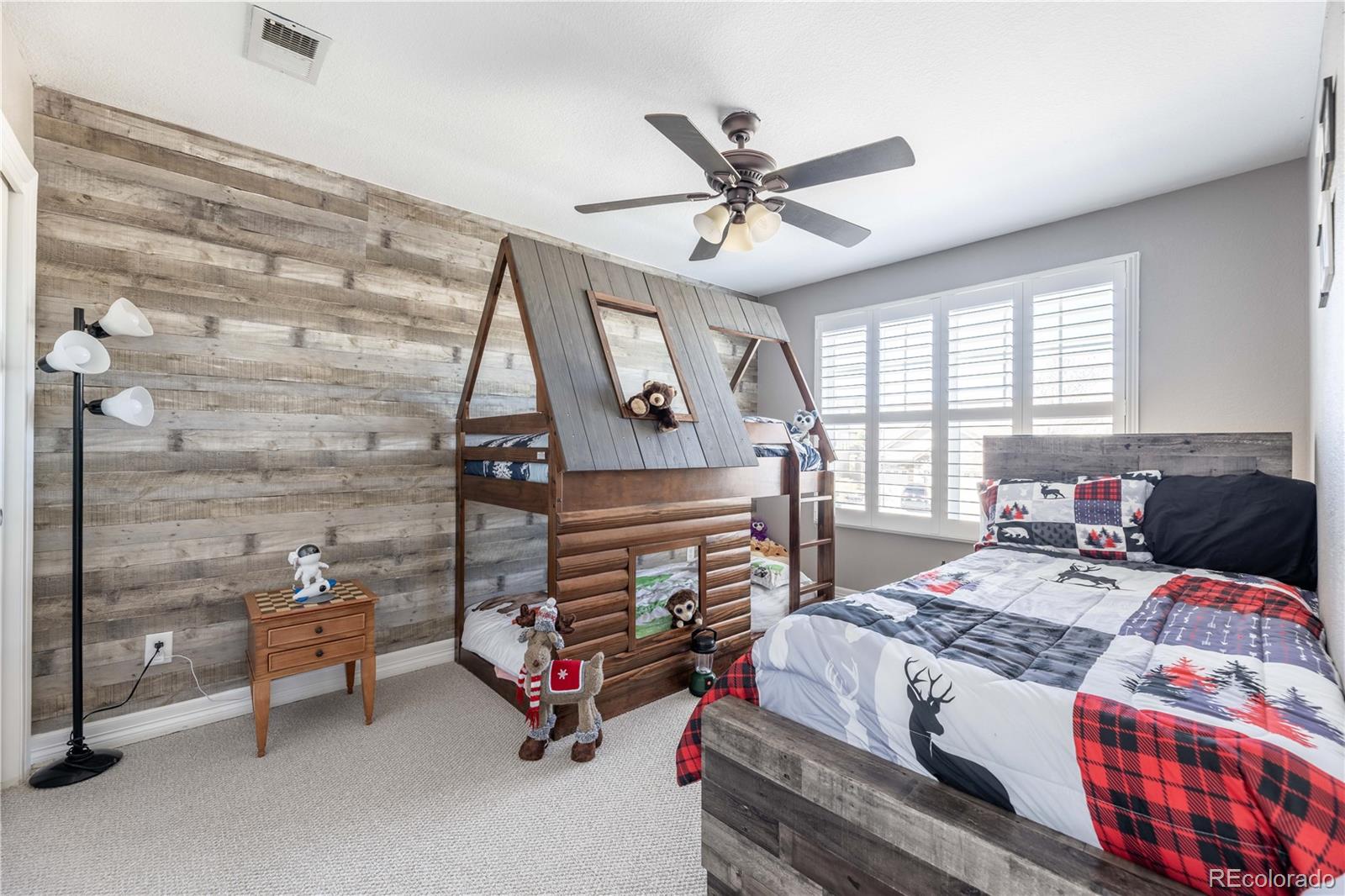 1610 Ridgetrail Court Castle Rock, CO 80104 - Photo 22 of 50 a bedroom with a bed a chandelier and a dresser