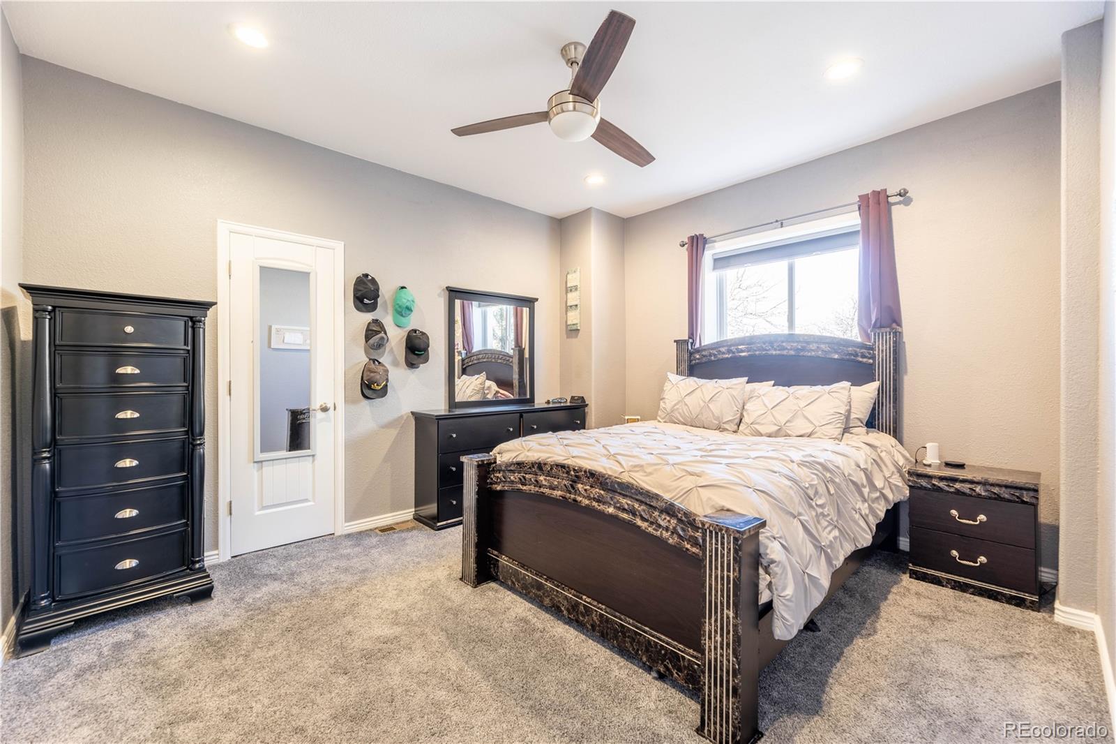 1610 Ridgetrail Court Castle Rock, CO 80104 - Photo 33 of 50 a bedroom with a bed a lamp and a dresser