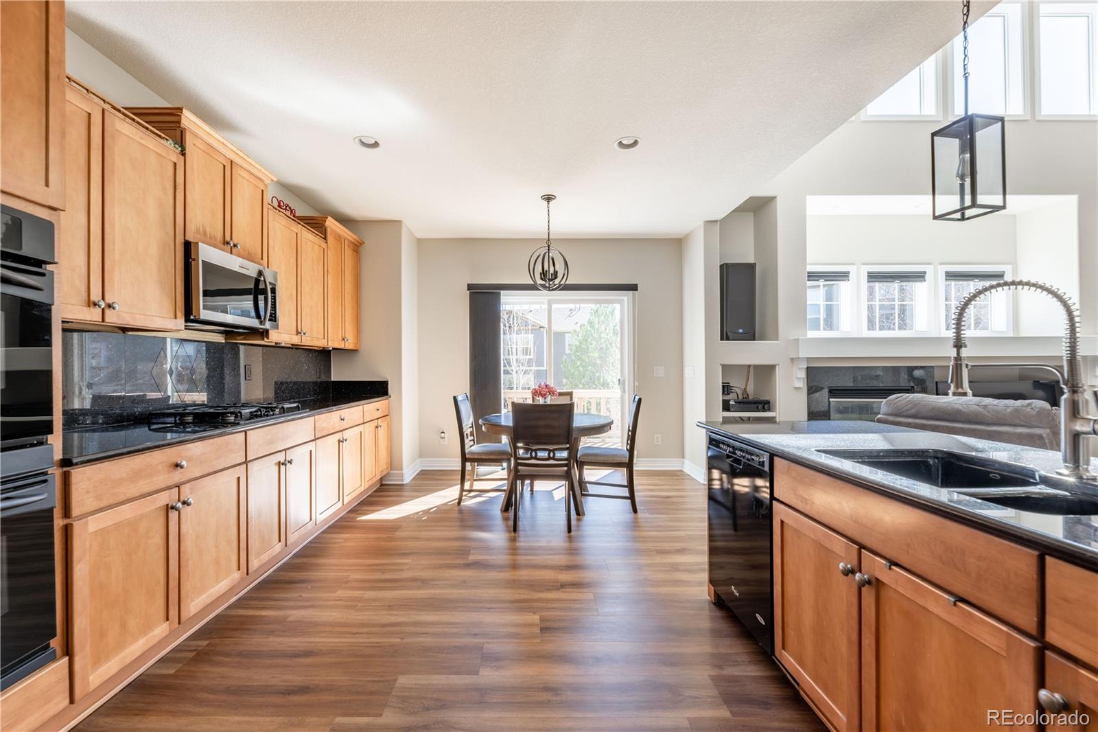 1610 Ridgetrail Court Castle Rock, CO 80104 - Photo 5 of 50 a kitchen with stainless steel appliances a kitchen island hardwood floor sink stove dining table and chairs