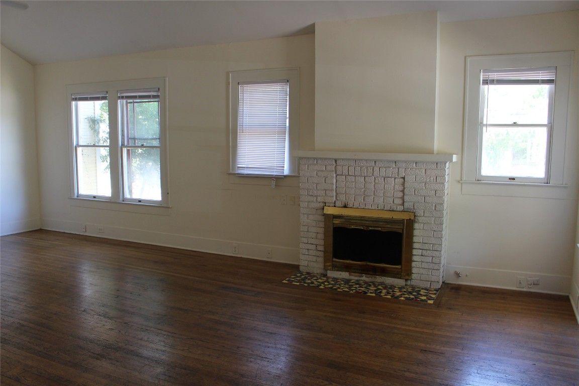 2826 Salado Street Austin, TX 78705 - Photo 7 of 29 an empty room with wooden floor fireplace and windows