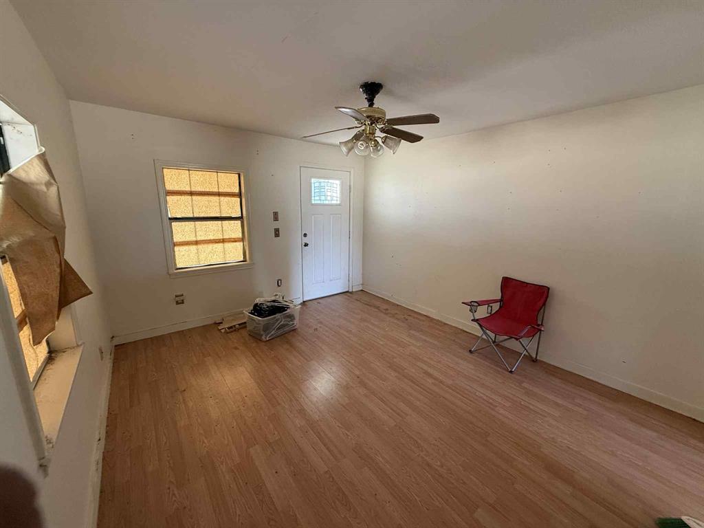 110 Hickory Street Roscoe, TX 79545 - Photo 2 of 6 an empty room with windows and ceiling fan view