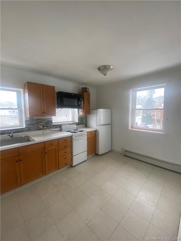 a large kitchen with a refrigerator sink and cabinets