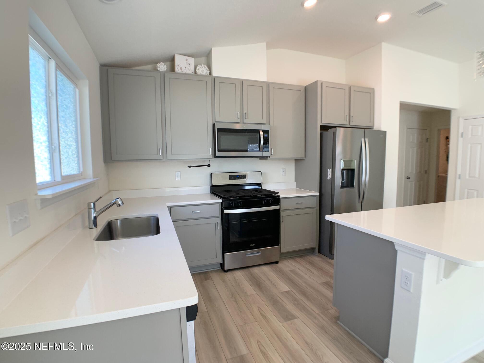 7948 Rippa Vly Way Jacksonville, FL 32222 - Photo 17 of 30 a kitchen with a refrigerator a stove top oven a sink and dishwasher