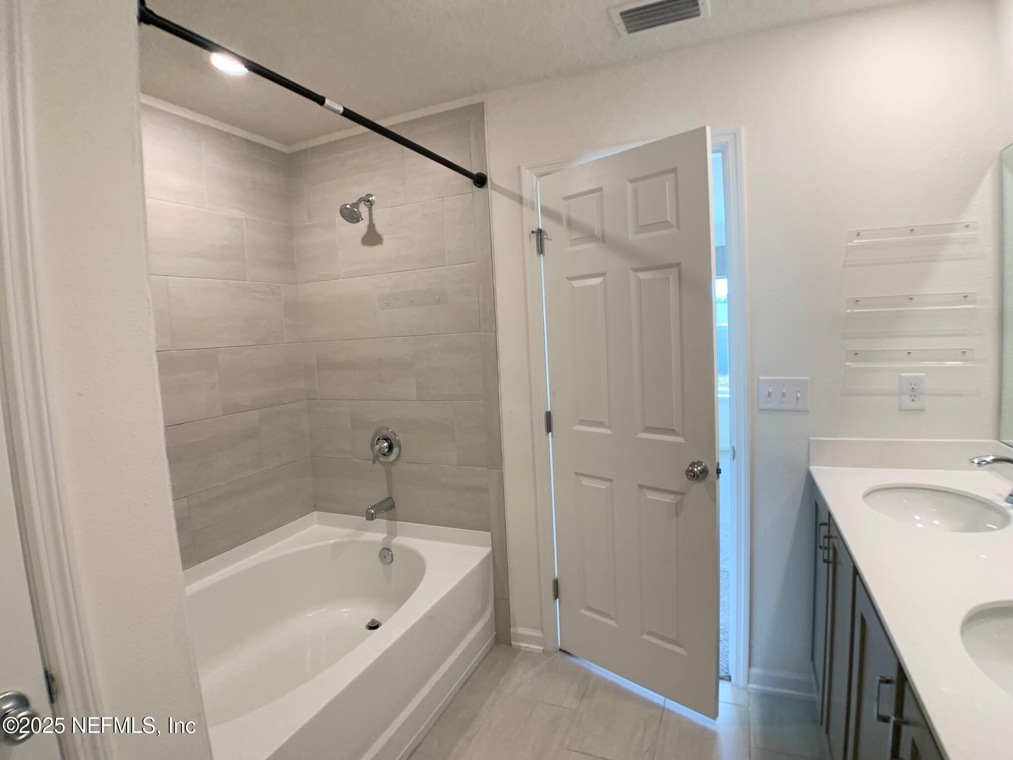 7948 Rippa Vly Way Jacksonville, FL 32222 - Photo 23 of 30 a bathroom with a tub shower sink vanity and a sink