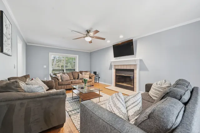 a living room with furniture a fireplace and a flat screen tv