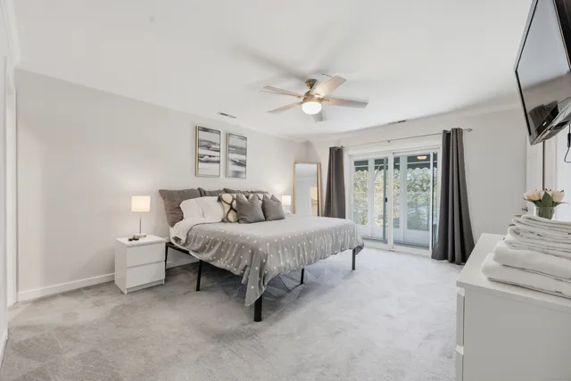 a spacious bedroom with a bed and a flat screen tv