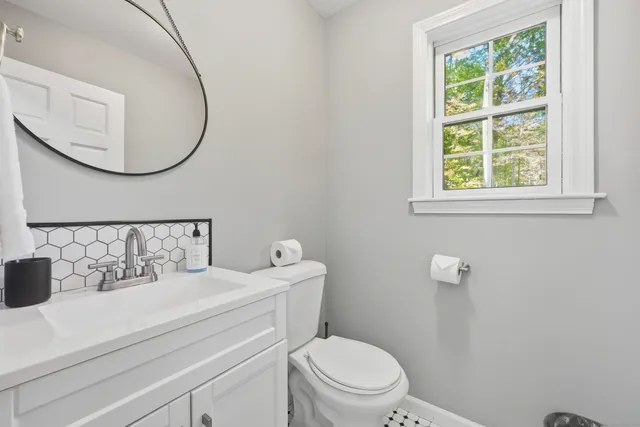 a bathroom with a sink mirror and toilet